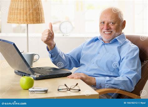 Smiling man with thumbs up at computer